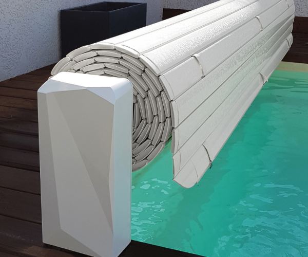 Piscina cubierta con una rollo de tela blanca sobre su superficie