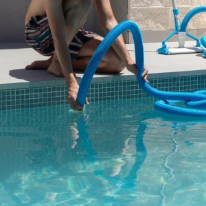unrecognizable-young-man-crouched-connecting-automatic-swimming-pool-cleaner-water